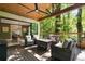 Cozy outdoor porch with comfortable seating, a fire pit, and a view of the serene backyard at 3390 River Ferry Dr, Alpharetta, GA 30022