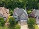 Aerial view of a well-maintained home with a large yard and two-car garage in a wooded neighborhood at 4527 Village Springs Run, Dunwoody, GA 30338