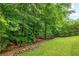 Lush backyard with mature trees and green lawn, providing a serene outdoor space at 4527 Village Springs Run, Dunwoody, GA 30338