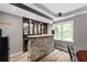Basement bar features stone accents, a built-in bar, and hardwood floors at 4527 Village Springs Run, Dunwoody, GA 30338