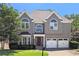 Charming two-story home featuring a well-manicured lawn, two-car garage, and stylish architectural details at 4527 Village Springs Run, Dunwoody, GA 30338