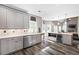Well-lit kitchen featuring white cabinets, stainless steel appliances, and an open layout to living area at 4527 Village Springs Run, Dunwoody, GA 30338
