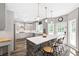 Bright kitchen features a stone-clad island with bar seating, pendant lighting, and stainless steel appliances at 4527 Village Springs Run, Dunwoody, GA 30338