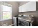 Convenient laundry room with modern washer, dryer, and storage cabinets at 4527 Village Springs Run, Dunwoody, GA 30338