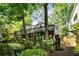Landscaped backyard with a staircase and mature trees providing shade, creating a secluded outdoor oasis at 1367 Ormewood Se Ave, Atlanta, GA 30316