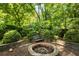 Secluded backyard with a brick fire pit and lush landscaping, offering a peaceful outdoor space at 1367 Ormewood Se Ave, Atlanta, GA 30316