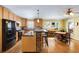 Kitchen featuring wood cabinets, black appliances, island seating, and eat in dining area at 1367 Ormewood Se Ave, Atlanta, GA 30316