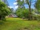 Expansive grassy backyard with mature trees, featuring a patio extending from the home at 2049 Rector Sw Dr, Atlanta, GA 30311