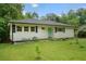 Charming ranch-style home with a well-maintained lawn, white siding, and a vibrant, colorful front door at 2049 Rector Sw Dr, Atlanta, GA 30311