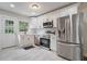 This modern kitchen is equipped with stainless steel appliances, white cabinets, and neutral tile flooring at 2049 Rector Sw Dr, Atlanta, GA 30311