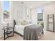 Bedroom with white linens and a gray throw blanket, with two large windows providing natural light at 370 2Nd St, Fayetteville, GA 30214