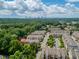 Community aerial view, showcasing townhouse neighborhood near wooded area with downtown skyline in the background at 4355 Parkside Pl, Sandy Springs, GA 30342