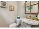 Charming powder room features a pedestal sink, decorative mirror, and stylish fixtures at 4355 Parkside Pl, Sandy Springs, GA 30342