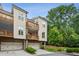 Townhouse showcasing multiple balconies, a two-car garage, and manicured landscaping at 4355 Parkside Pl, Sandy Springs, GA 30342