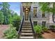 Brick townhouse exterior featuring a modern front door, landscaped yard, and inviting stairway at 4355 Parkside Pl, Sandy Springs, GA 30342