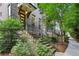 Charming townhouse entrance with stone steps, black railings, and lush landscaping, welcoming guests at 4355 Parkside Pl, Sandy Springs, GA 30342