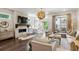 Bright living room features a brick fireplace, dark hardwood floors, and a striking ornamental chandelier at 4355 Parkside Pl, Sandy Springs, GA 30342
