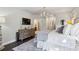 This well-lit main bedroom features a chandelier, TV, and a large dresser, creating an elegant yet comfortable space at 4355 Parkside Pl, Sandy Springs, GA 30342