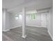 Finished basement with gray wood-look floors, support beams, and a white painted door and trim at 623 Montevista Sw St, Atlanta, GA 30310