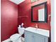 Stylish powder room features bold red walls, modern sink, and matching black framed mirror at 628 Warren Ave, Scottdale, GA 30079