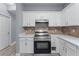 Modern kitchen featuring stainless steel oven and stove, white cabinets, and stone countertops at 628 Warren Ave, Scottdale, GA 30079