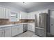 Bright kitchen with white cabinets, stone countertops, and stainless steel appliances at 628 Warren Ave, Scottdale, GA 30079