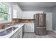 Kitchen with stainless steel appliances, white cabinets, stone countertops, and stone backsplash at 628 Warren Ave, Scottdale, GA 30079