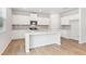 Bright modern kitchen featuring white cabinets, stainless steel appliances, and a granite-topped island at 7193 Brushwood Bend (Lot 33), Lithonia, GA 30058
