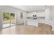 Bright kitchen featuring white cabinets, a granite island, stainless steel appliances, and sliding glass doors at 7193 Brushwood Bend (Lot 33), Lithonia, GA 30058