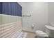 A cozy bathroom features a white toilet and a shower with a stylish striped curtain at 870 Mayson Turner Rd Nw # 1111, Atlanta, GA 30314