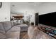 Open-concept living room featuring wood floors, a comfortable gray couch, and a modern entertainment center and open to kitchen at 870 Mayson Turner Rd Nw # 1111, Atlanta, GA 30314