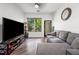 Comfortable living room features hardwood flooring, a gray couch, entertainment system and windows with tree-lined view at 870 Mayson Turner Rd Nw # 1111, Atlanta, GA 30314