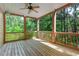 The back porch features a ceiling fan and wood flooring with a view of the backyard at 140 Longwater Cv, Roswell, GA 30075