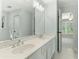 Bathroom with double sinks, framed mirror, view into ensuite bedroom and the shower at 140 Longwater Cv, Roswell, GA 30075