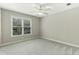 Bedroom features light grey walls and carpeting with a large window and a ceiling fan at 140 Longwater Cv, Roswell, GA 30075