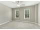 This bedroom features neutral paint, plush carpet, a ceiling fan, and two windows with white blinds at 140 Longwater Cv, Roswell, GA 30075