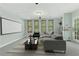 This staged bonus room features a large television screen and plenty of comfortable seating at 140 Longwater Cv, Roswell, GA 30075