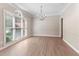 Bright dining room featuring hardwood floors, large windows, and an elegant chandelier at 140 Longwater Cv, Roswell, GA 30075