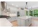 Bright kitchen features white cabinetry, stainless steel appliances, and an island with countertop seating at 140 Longwater Cv, Roswell, GA 30075
