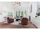 Staged living room with vaulted ceilings, a fireplace, and views of the backyard at 140 Longwater Cv, Roswell, GA 30075