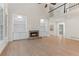 Hardwood living room featuring a fireplace, built-ins, and large windows at 140 Longwater Cv, Roswell, GA 30075