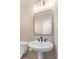 Powder room featuring a pedestal sink, modern mirror, and neutral walls at 140 Longwater Cv, Roswell, GA 30075