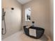 Modern bathroom featuring a soaking tub, tiled walls, and black fixtures for a unique spa experience at 245 Roycroft Ln, Fayetteville, GA 30214