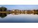 Scenic view of a row of homes reflected in the calm waters of the community pond at 245 Roycroft Ln, Fayetteville, GA 30214