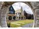 Beautiful landscaping and unique architecture are framed by a custom stone archway and path at 245 Roycroft Ln, Fayetteville, GA 30214