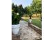 Landscaped backyard featuring a charming stone pathway and lush green lawn at 3554 Umatilla Sw Ln, South Fulton, GA 30331