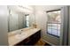 Bathroom features a double vanity, a window with natural light, and a stylish design with dark wood cabinets at 3554 Umatilla Sw Ln, South Fulton, GA 30331