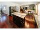 Open-concept kitchen with dark wood floors, stainless steel fridge, and large breakfast island with marble countertop at 3554 Umatilla Sw Ln, South Fulton, GA 30331