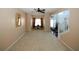 Spacious living room with neutral carpet, a ceiling fan, and a view of the entry area and staircase at 3554 Umatilla Sw Ln, South Fulton, GA 30331