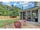 View of a deck and screened-in porch with an outdoor fireplace, overlooking the spacious backyard at 4191 Secret Shoals Way, Buford, GA 30518